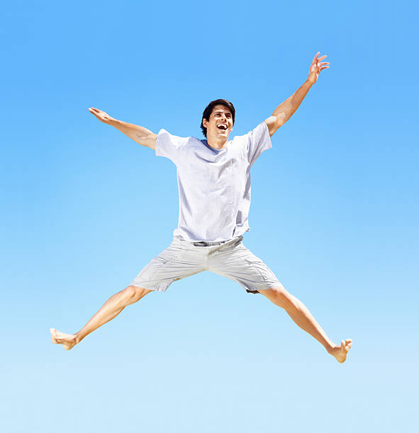 istock Excited young guy jumping in the air against clear sky 157568123