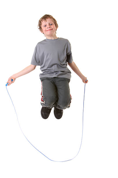 happy boy jumping rope stock photo