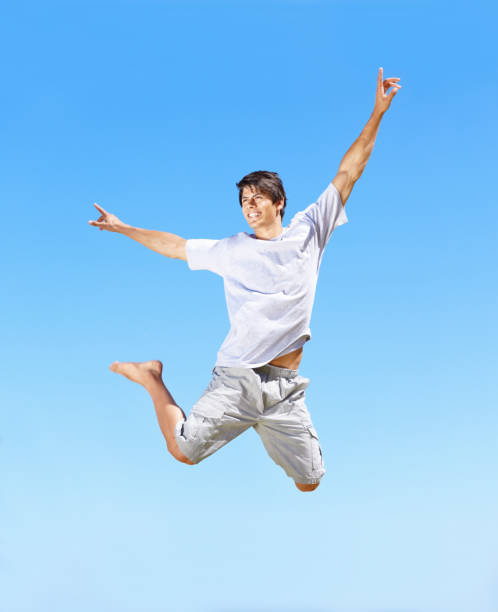 istock Excited young guy jumping with joy against blue sky 157568265