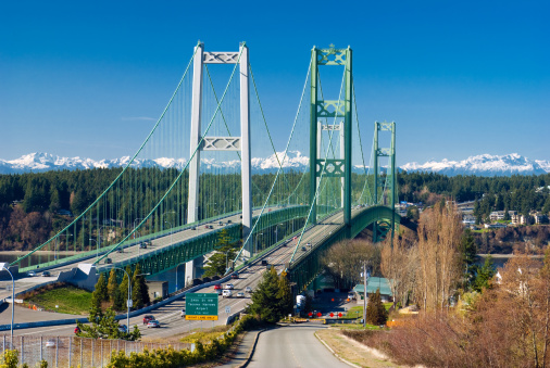 The Tacoma Narrows Bridge in Washington state linking the city of Tacoma with Gig Harbor of the Kitsap Peninsula, with the Olympic Mountain range in the distance.