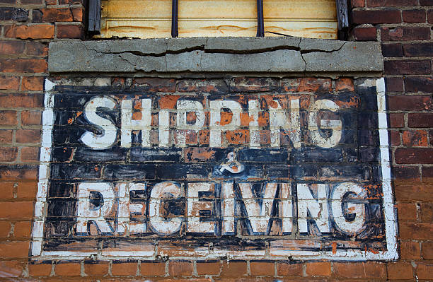 Shipping and receiving painted sign on brick wall of run down warehouse/ factory in downtown Detroit