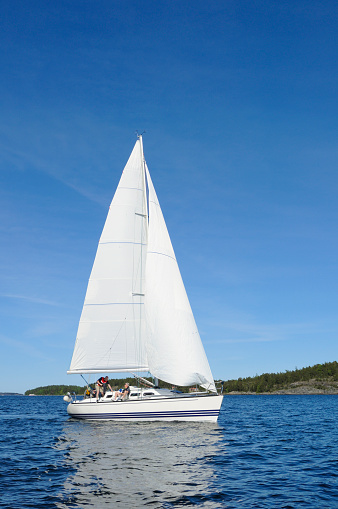 Sailboat in the archipelago of Stockholm, Sweden. People moving on the boat.