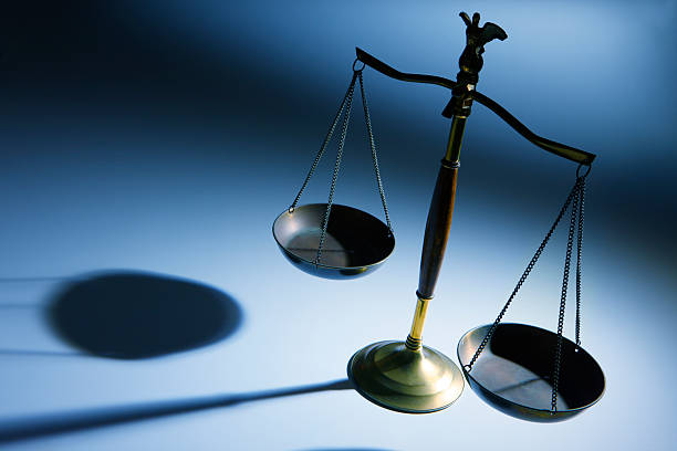 lone justicia escala sobre fondo azul simple - weight scale justice balance scales of justice fotografías e imágenes de stock