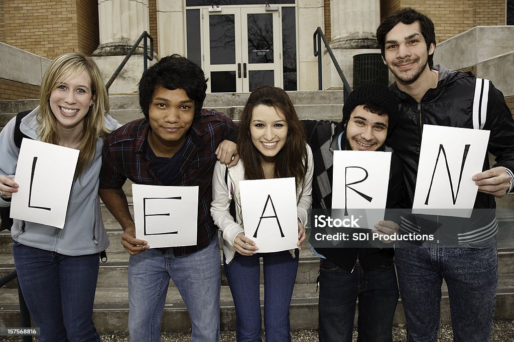 Young Group Holding Learn Sign to Signify Importance of Education Young Group Holding Learn Sign to Signify Importance of Education. Holding Stock Photo