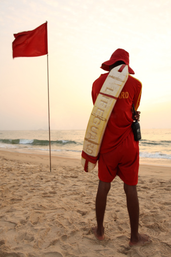 Male Lifeguard on duty at the beach in Northern Goa, India.