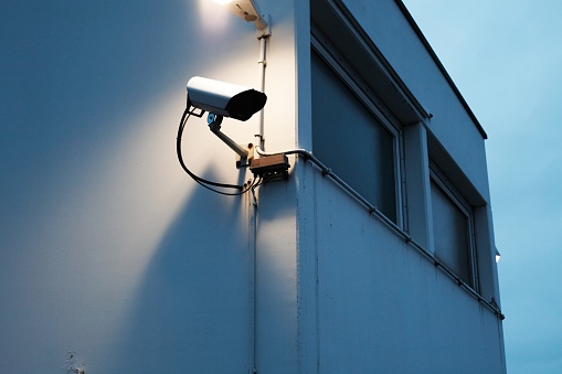 CCTV camera in store against the blured background of a clothing store. Security video system.