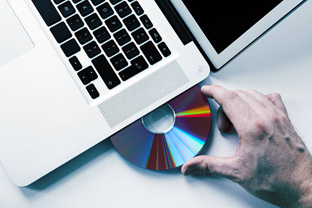 istock Hand Inserting a DVD in the Laptop 157569597