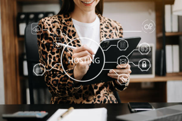 istock Web hosting concept, woman using computer, tablet and presses his finger on the virtual screen inscription Hosting on desk, Internet, business, digital technology concept. 1575697441
