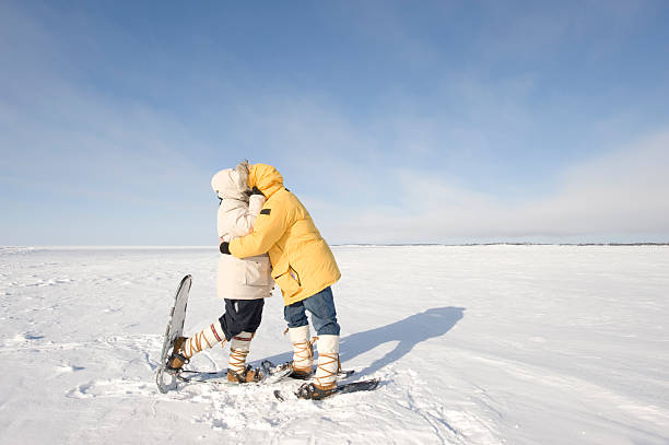 Arctic Kiss, Yellowknife. Two snowshoers kiss on the frozen snow on Great Slave Lake in Canada's Arctic.  Click to view similar images. great slave lake stock pictures, royalty-free photos & images