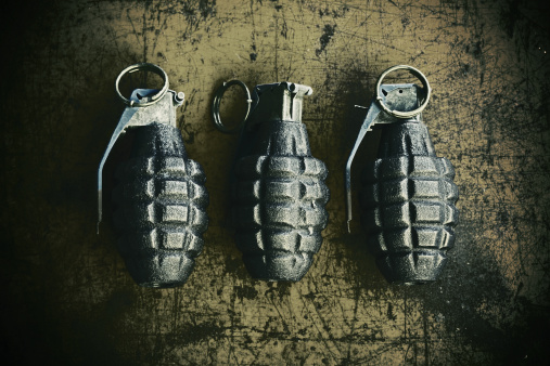 3 hand grenade (pineapple style) on scratchy rusty background