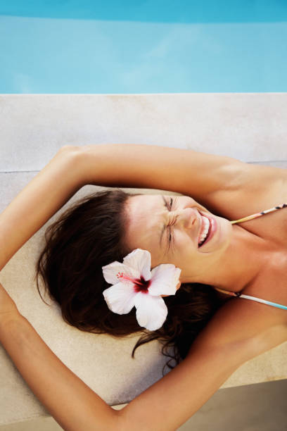 istock Excited young woman lying by swimming pool 157570187