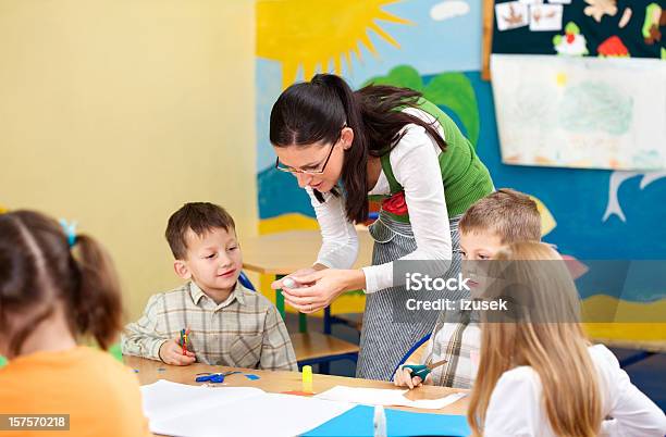 Teacher Helping Pupils With Artwork Stock Photo - Download Image Now - 6-7 Years, Adult, Art