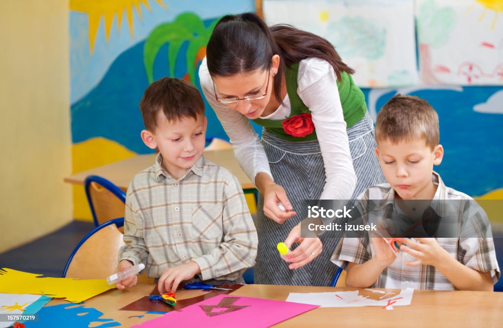 Profesor ayudando a los alumnos con obras de arte - Foto de stock de Imagen compuesta libre de derechos