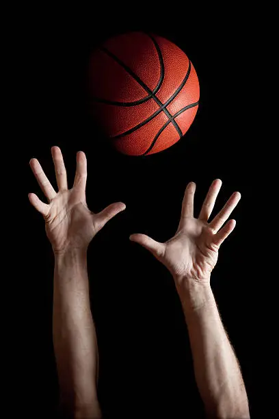 A basketball player reaching for the ball.