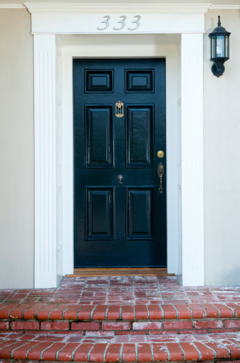 Entrance and black solid wood front door to a traditional house.