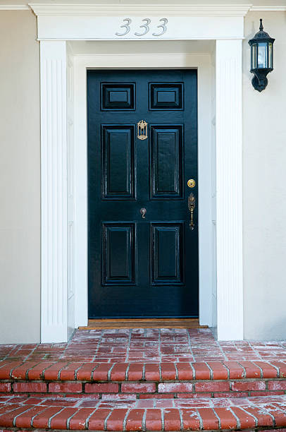 Entrance With Front Door Entrance and black solid wood front door to a traditional house. doorstep stock pictures, royalty-free photos & images