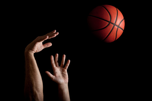 A shooter shooting the  basketball on a black background.