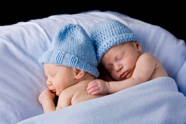 istock Newborn Twins Wrapped in Blue Blanket with Knit Hats 157570434
