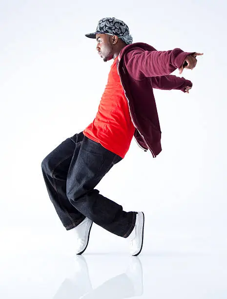 breakdancer balancing on the tip of his toes, on white background - side view