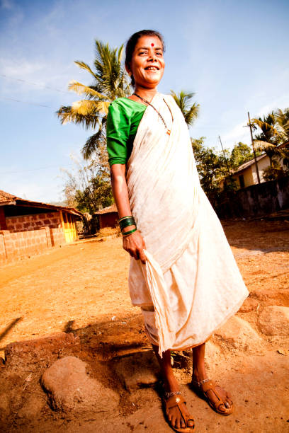 un allegro rurale donna indiana in piedi in un villaggio - senior adult fragility human eye wrinkled foto e immagini stock