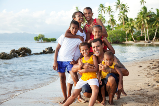 Photo of a Fijian family of seven posing for a photo at a local scenic beach. Savusavu, Fiji Islands.