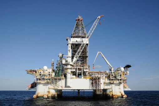 A floating deep water semi-submersible oil drilling on location at sea. A dynamically positioned oil rig.