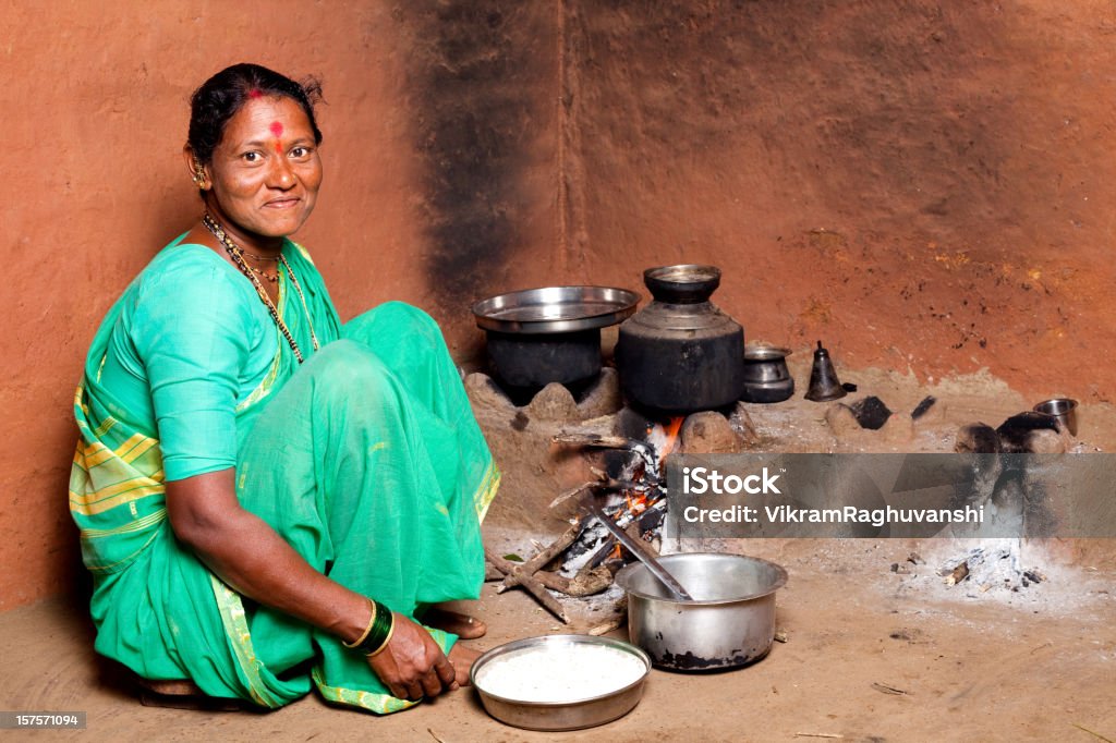 Una mujer India Rural cocinar alimentos en la cocina - Foto de stock de Ama de casa libre de derechos