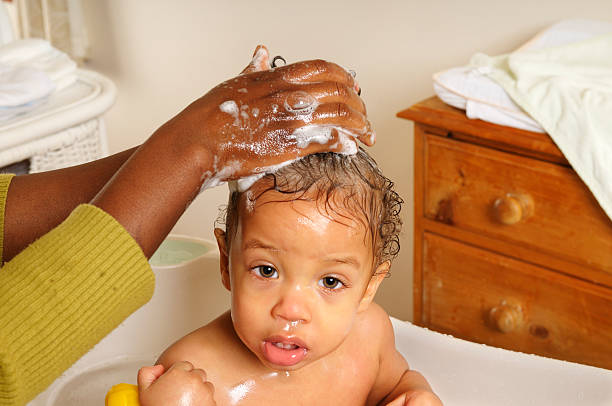 Close Up View Of A Baby Having His Hair Washed A close up view of a baby having his hair washed black woman washing hair stock pictures, royalty-free photos & images