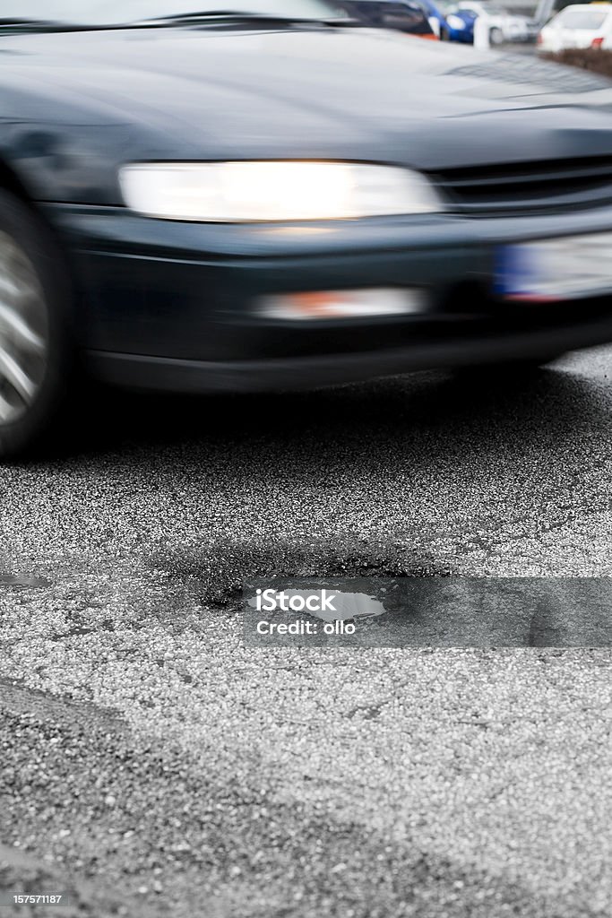 Avvicinarsi auto, di pothole - Foto stock royalty-free di Buca della Strada