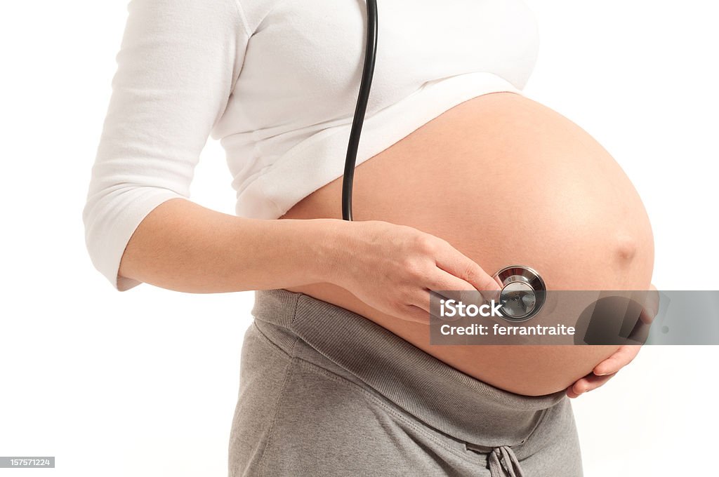 Schwangere Frau mit nackten Bauch hält Stethoskop - Lizenzfrei Erwachsene Person Stock-Foto