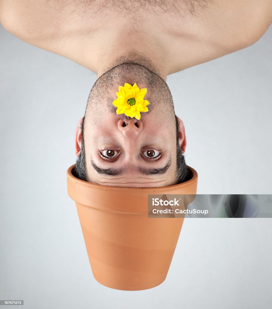 Plant boy with a yellow flower Young man who grows in a pot of gardening as a plant.  Eccentric Stock Photo