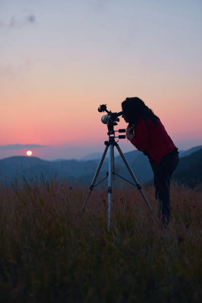 istock Female astronomer looking at the sun with a telescope. 1575716122