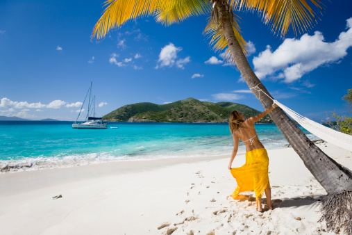 woman in bikini and sarong having fun at the beach on a tropical island in the Caribbean