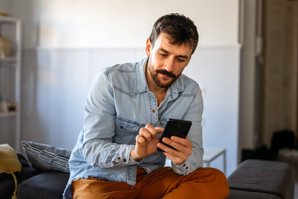 istock Young man using cellphone for work, social media or relaxation. Smart phone people concept. 1575716744