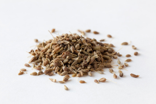 A pile of anise seeds on a white background.