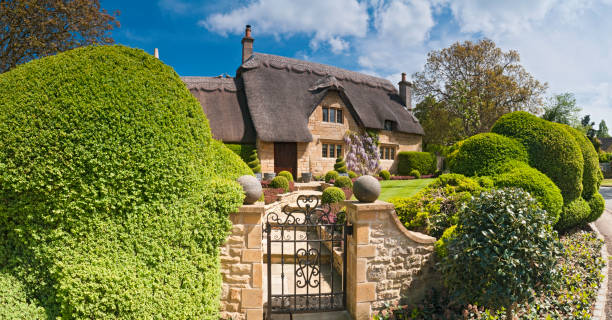 idílica país cabaña con techo de paja hermosos jardines de verano cotswolds, reino unido - casita de campo fotografías e imágenes de stock