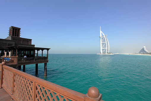 Wooden Bridge Over Water Jumeirah Resort and Burj Al Arab hotel in the background.