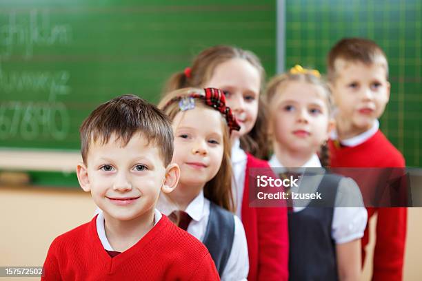 School Kids Standing In A Row Classroom Stock Photo - Download Image Now - Green Color, School Uniform, 6-7 Years