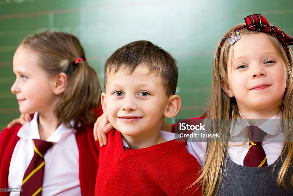 Happy School Kids Posing Together, Portrait Portrait of a school boy and two girls embracing, smiling. Girls Stock Photo