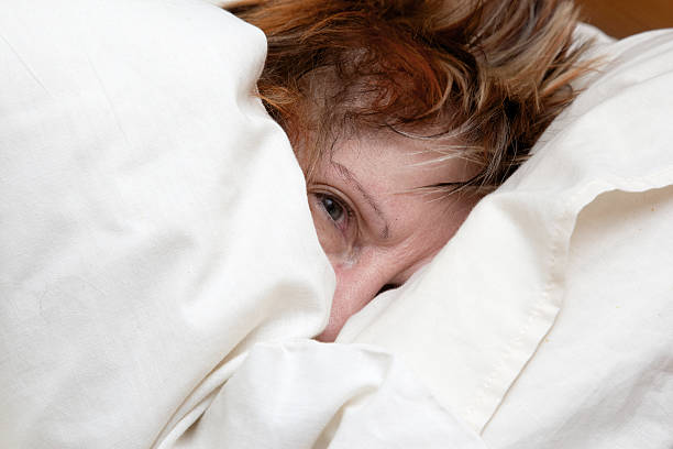 Mature woman snuggled up in bed