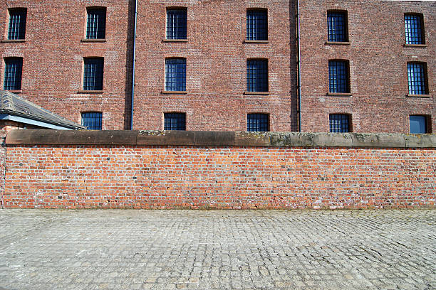 mur de brique rouge avec trottoir à l'albert dock, liverpool - albert dock photos et images de collection