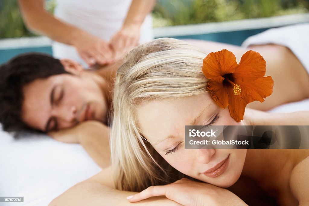 Casal jovem desfrutando de uma relaxante massagem corporal no spa - Foto de stock de 18-19 Anos royalty-free