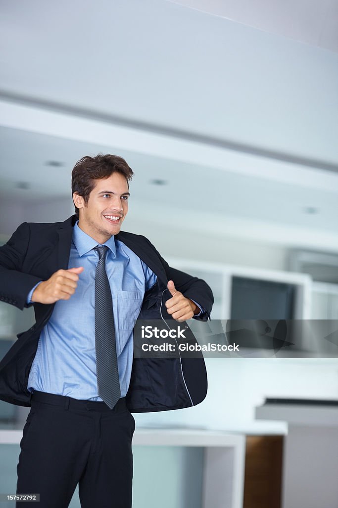 Young business man putting en su abrigo - Foto de stock de Vestirse libre de derechos