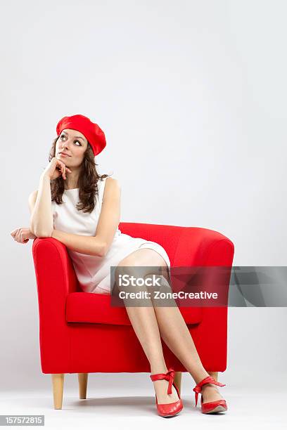 Hermosa Chica En Un Sillón Rojo De Pensamiento Foto de stock y más banco de imágenes de Adulto - Adulto, Apoyarse, Calzado