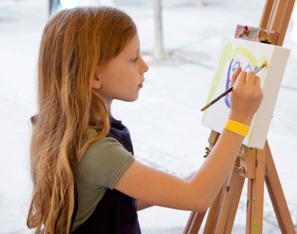 istock Young blond girl artist at her easel. 157572917