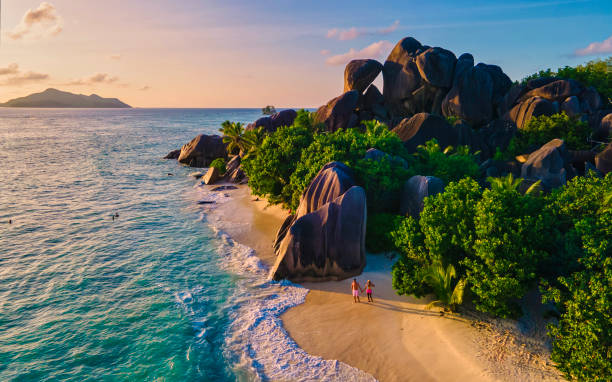 istock Anse Source d'Argent beach, La Digue Island, Seyshelles, Drone aerial view of La Digue Seychelles bird eye view, couple men and woman walking at the beach during sunset at a luxury vacation 1575731417