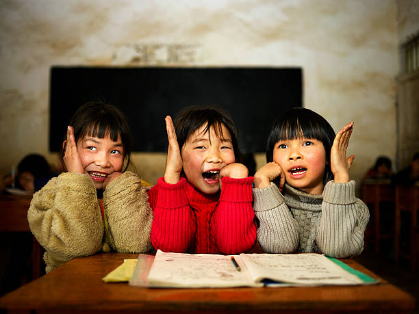 Chinese school children Chinese school children in a rural village school, raising hands in Chinese way. yangshuo stock pictures, royalty-free photos & images