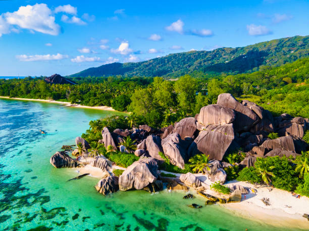 istock Anse Source d'Argent beach, La Digue Island, Seyshelles, Drone aerial view of La Digue Seychelles bird eye view, couple men and woman walking at the beach during sunset at a luxury vacation 1575749706