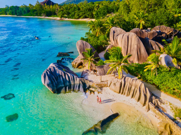 istock Anse Source d'Argent beach, La Digue Island, Seyshelles, Drone aerial view of La Digue Seychelles bird eye view, couple men and woman walking at the beach during sunset at a luxury vacation 1575752756