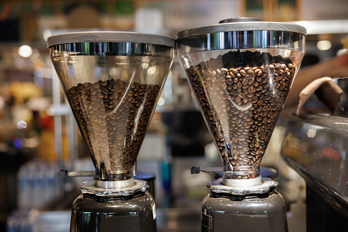 coffee beans in bean hopper, part of coffee machine in a coffee shop.